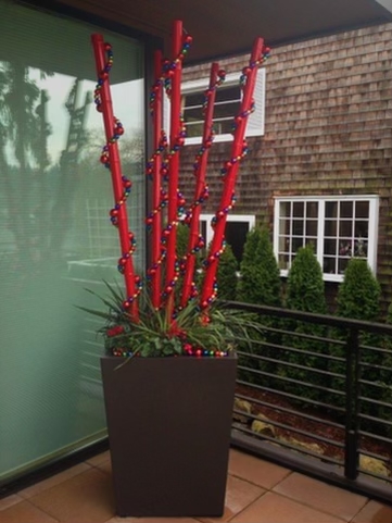 Festive Container Planting Red painted bamboo wrapped with string of ornaments